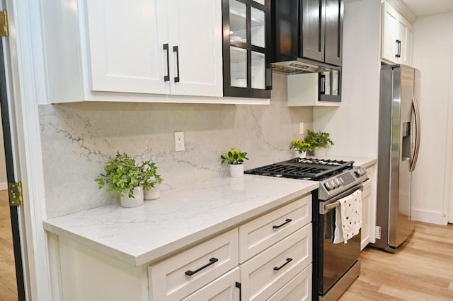 25190 Elwood Rd, Sanger, CA 93657 - kitchen featuring stainless steel appliances, backsplash, light wood finished floors, glass insert cabinets, and white cabinetry