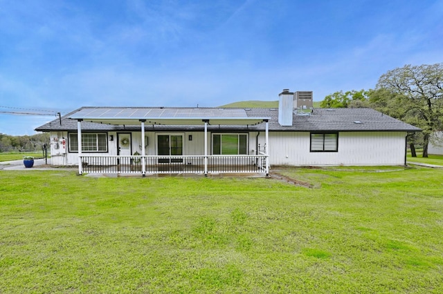 25190 Elwood Rd, Sanger, CA 93657 - back of property featuring a yard, roof mounted solar panels, a chimney, and covered porch
