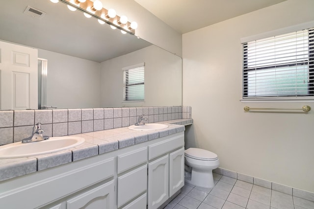 6447 N Vagedes Ave, Fresno, CA 93711 - bathroom featuring double vanity, tile patterned floors, plenty of natural light, and tasteful backsplash