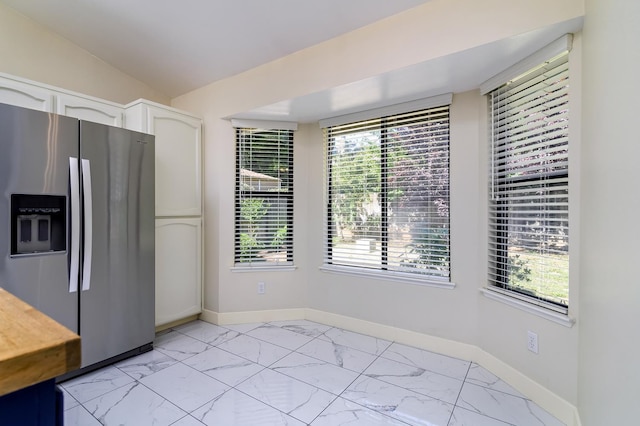 6447 N Vagedes Ave, Fresno, CA 93711 - kitchen featuring stainless steel fridge, light marble finish flooring, white cabinetry, and lofted ceiling
