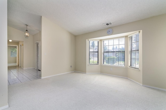6447 N Vagedes Ave, Fresno, CA 93711 - empty room with carpet floors, healthy amount of natural light, a textured ceiling, and lofted ceiling