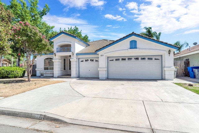 5811 W Beechwood Ave, Fresno, CA 93722 - view of front facade with stucco siding, a garage, a tiled roof, and concrete driveway