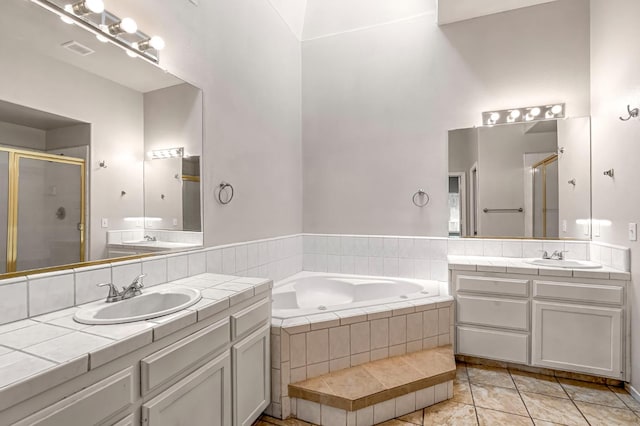 5811 W Beechwood Ave, Fresno, CA 93722 - bathroom featuring a shower stall, two vanities, and a bath