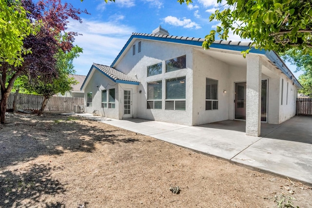 5811 W Beechwood Ave, Fresno, CA 93722 - rear view of house featuring stucco siding, a patio area, a tile roof, and a chimney