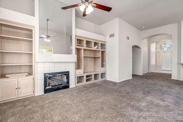 5811 W Beechwood Ave, Fresno, CA 93722 - unfurnished living room with ceiling fan, arched walkways, carpet flooring, and a fireplace