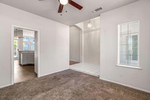 5811 W Beechwood Ave, Fresno, CA 93722 - spare room featuring ceiling fan, carpet floors, and arched walkways