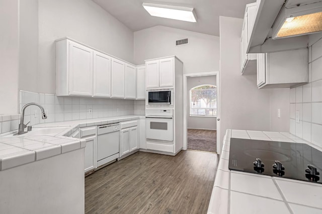 5811 W Beechwood Ave, Fresno, CA 93722 - kitchen featuring white appliances, extractor fan, tile counters, decorative backsplash, and high vaulted ceiling