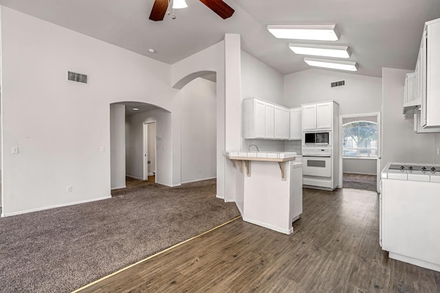 5811 W Beechwood Ave, Fresno, CA 93722 - kitchen featuring built in microwave, a ceiling fan, white oven, a peninsula, and arched walkways