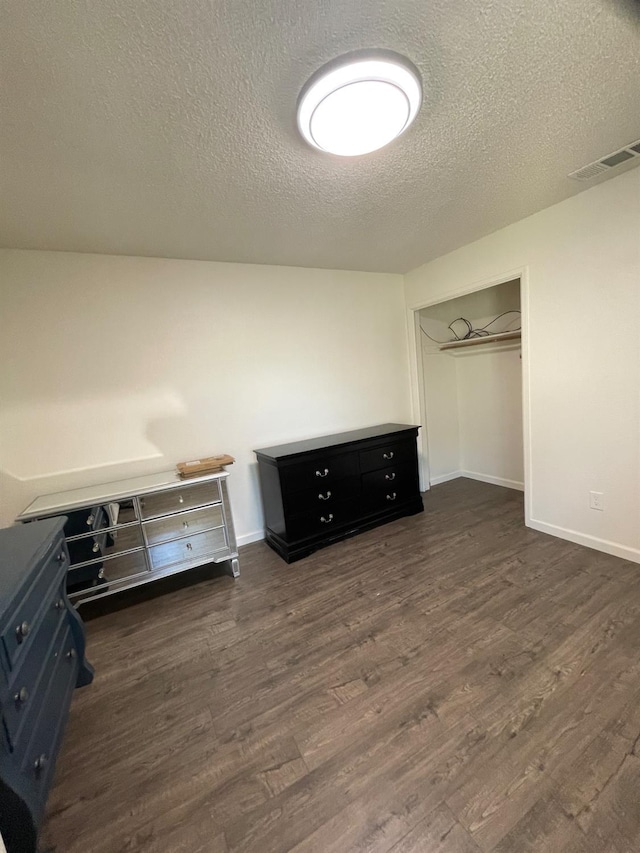 1027 W Dakota Ave Unit 102, Fresno, CA 93705 - unfurnished bedroom with dark wood-type flooring, a textured ceiling, and a closet