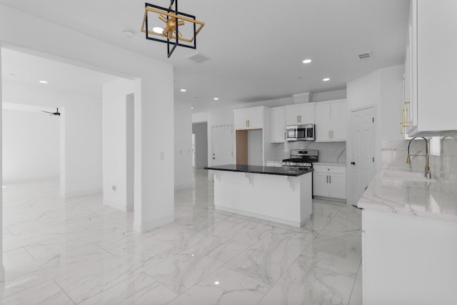 36950 Pauline Ave, Madera, CA 93636 - kitchen with appliances with stainless steel finishes, white cabinetry, recessed lighting, light marble finish floors, and a chandelier