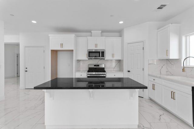 36950 Pauline Ave, Madera, CA 93636 - kitchen with appliances with stainless steel finishes, light marble finish flooring, recessed lighting, white cabinets, and a kitchen island