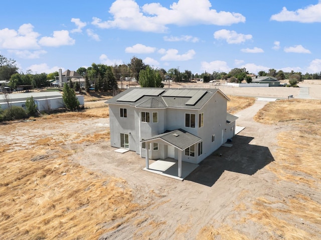 36950 Pauline Ave, Madera, CA 93636 - back of property with stucco siding, solar panels, and a patio