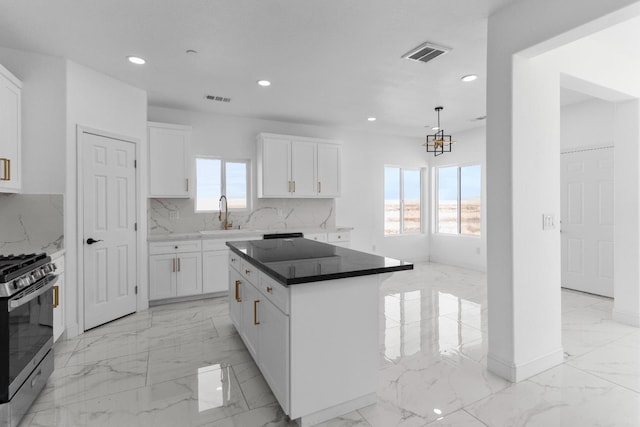 36950 Pauline Ave, Madera, CA 93636 - kitchen featuring stainless steel range with gas stovetop, light marble finish flooring, recessed lighting, white cabinets, and tasteful backsplash