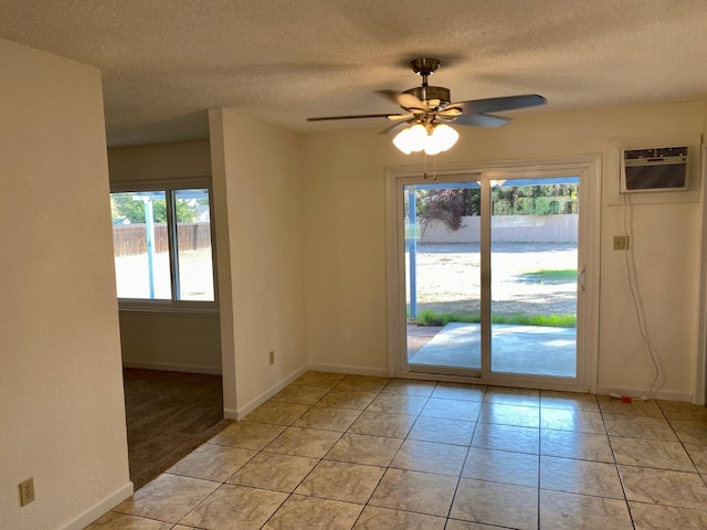 12173 Rd 36, Madera, CA 93636 - spare room featuring a textured ceiling, ceiling fan, an AC wall unit, and light tile patterned floors