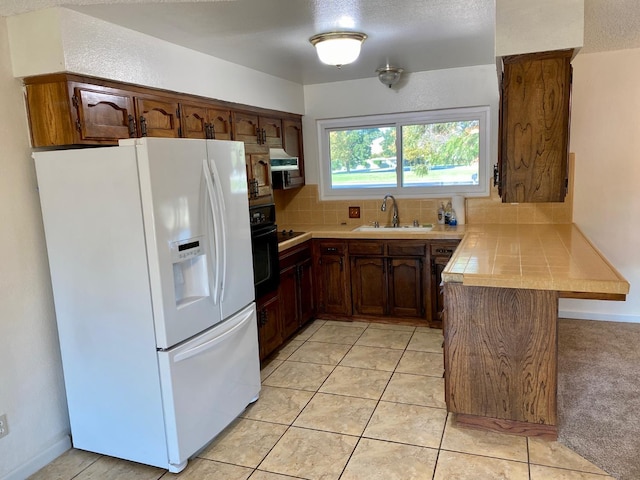 12173 Rd 36, Madera, CA 93636 - kitchen featuring white refrigerator with ice dispenser, range hood, a peninsula, backsplash, and black oven