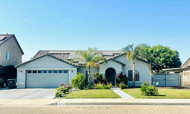 924 Palm Ave, Fowler, CA 93625 - view of front of house featuring stucco siding, an attached garage, driveway, and a tile roof