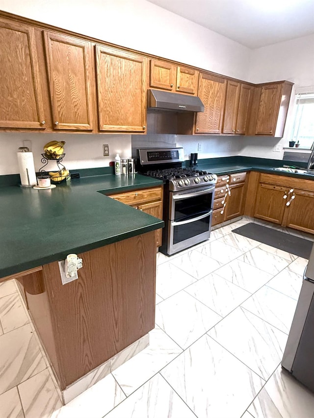 924 Palm Ave, Fowler, CA 93625 - kitchen featuring double oven range, under cabinet range hood, light marble finish floors, and brown cabinets