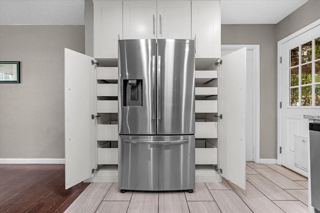 1440 E Fountain Way, Fresno, CA 93704 - kitchen with stainless steel fridge, light wood-type flooring, and white cabinetry
