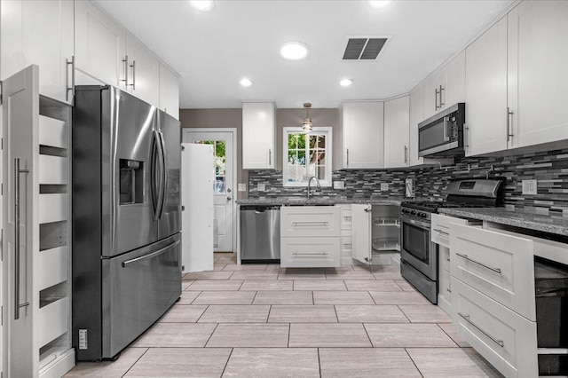 1440 E Fountain Way, Fresno, CA 93704 - kitchen featuring stainless steel appliances, decorative backsplash, dark stone counters, white cabinets, and recessed lighting