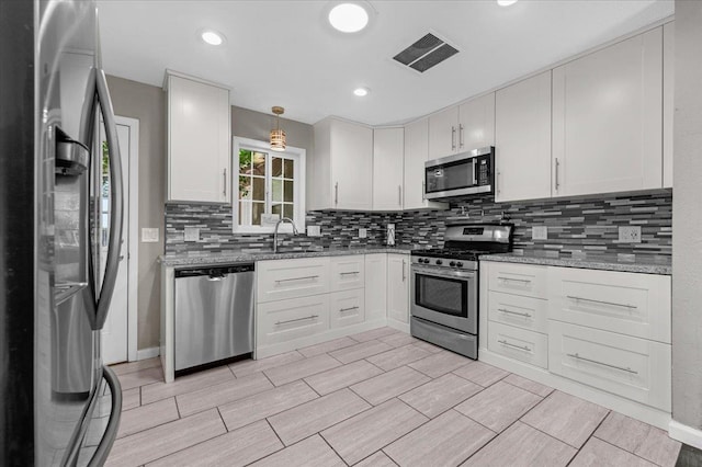 1440 E Fountain Way, Fresno, CA 93704 - kitchen with stainless steel appliances, decorative backsplash, white cabinets, and light stone countertops