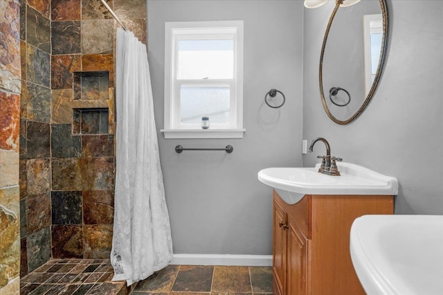 1440 E Fountain Way, Fresno, CA 93704 - bathroom featuring tiled shower, vanity, and stone finish floors