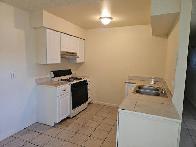 1490 N First, Fresno, CA 93703 - kitchen featuring gas range, under cabinet range hood, light tile patterned floors, white cabinets, and light countertops