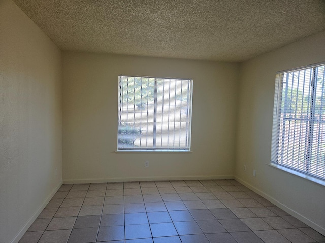 1490 N First, Fresno, CA 93703 - spare room featuring healthy amount of natural light, a textured ceiling, and light tile patterned flooring