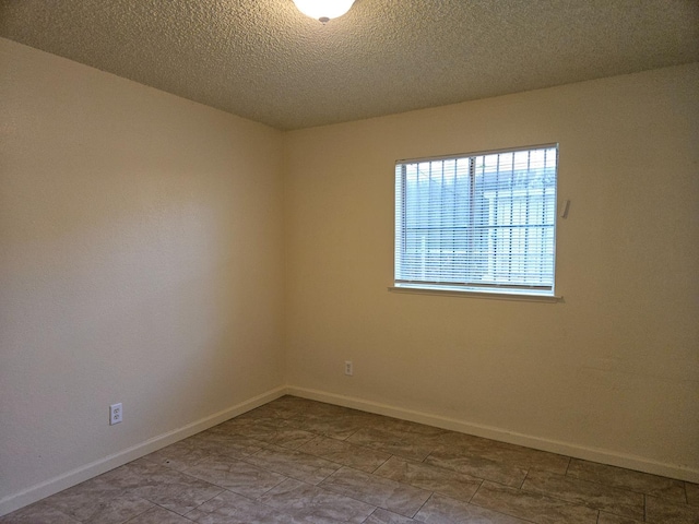 1490 N First, Fresno, CA 93703 - unfurnished room with baseboards and a textured ceiling