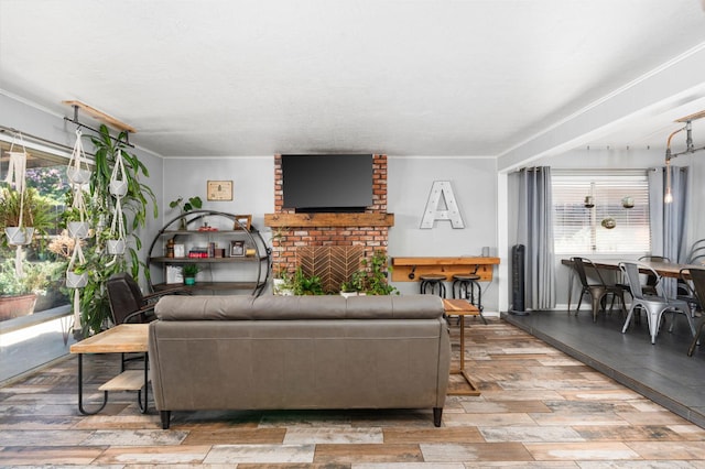 2344 E Menlo Ave, Fresno, CA 93710 - living area featuring plenty of natural light, wood-type flooring, a brick fireplace, and ornamental molding