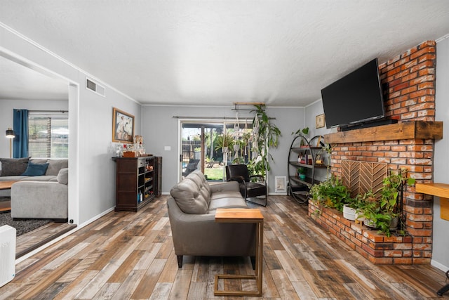 2344 E Menlo Ave, Fresno, CA 93710 - living room featuring hardwood / wood-style floors, plenty of natural light, a fireplace, and ornamental molding
