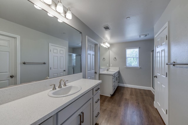 7393 E Michigan Ave, Fresno, CA 93737 - bathroom with a stall shower, two vanities, and wood finished floors