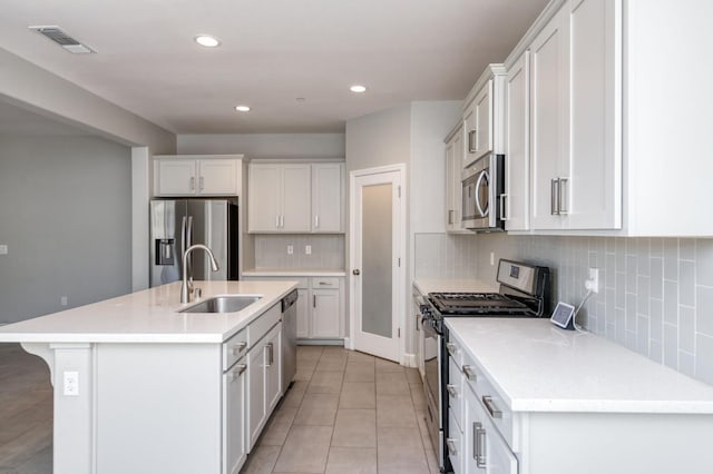 7393 E Michigan Ave, Fresno, CA 93737 - kitchen with stainless steel appliances, a kitchen island with sink, light tile patterned floors, white cabinets, and recessed lighting
