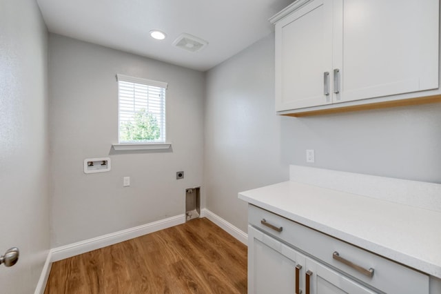 7393 E Michigan Ave, Fresno, CA 93737 - washroom featuring light wood finished floors, hookup for a washing machine, hookup for an electric dryer, and cabinet space