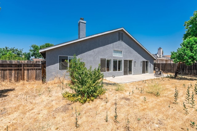 6431 E Inyo St, Fresno, CA 93727 - rear view of house featuring stucco siding, a patio area, a fenced backyard, and a chimney