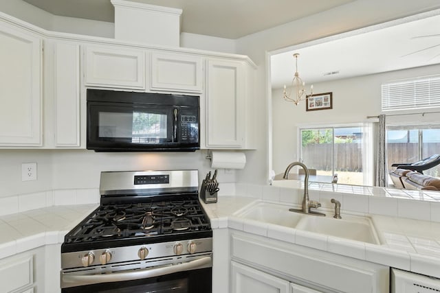 6431 E Inyo St, Fresno, CA 93727 - kitchen with black microwave, stainless steel range with gas cooktop, tile counters, white cabinetry, and a chandelier