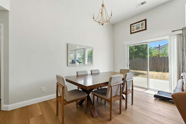 6431 E Inyo St, Fresno, CA 93727 - dining room featuring light wood-type flooring, a chandelier, and a high ceiling