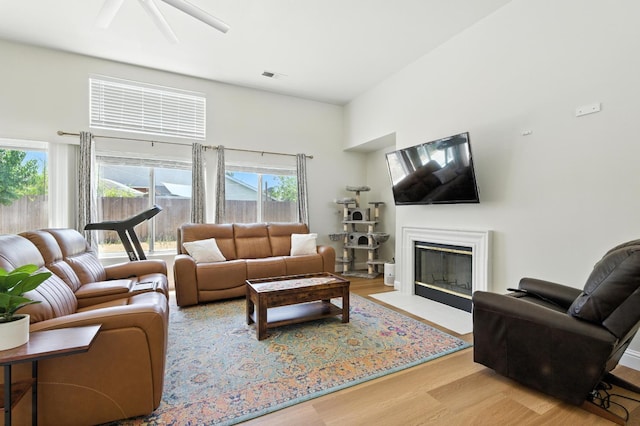 6431 E Inyo St, Fresno, CA 93727 - living area with wood finished floors, a fireplace with flush hearth, a ceiling fan, and a towering ceiling
