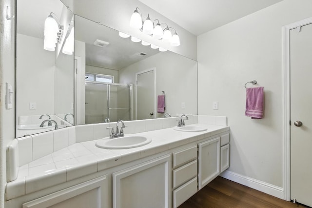 6431 E Inyo St, Fresno, CA 93727 - bathroom featuring double vanity, a stall shower, and wood finished floors