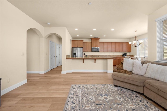 2481 S Via Versilia Dr, Fresno, CA 93727 - living area with a chandelier, recessed lighting, light wood-type flooring, and arched walkways