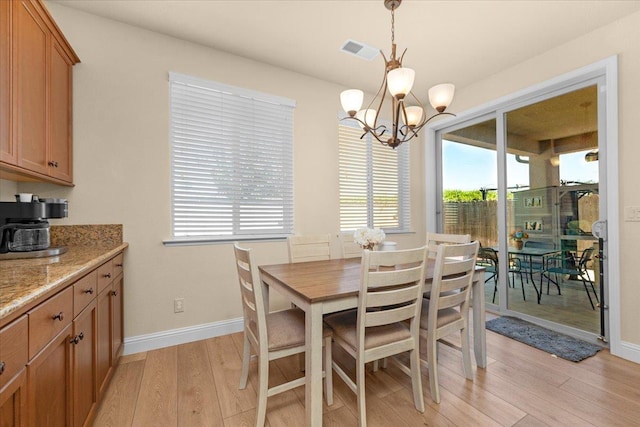 2481 S Via Versilia Dr, Fresno, CA 93727 - dining area featuring light wood-type flooring and a chandelier
