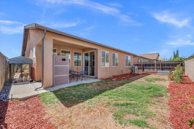2481 S Via Versilia Dr, Fresno, CA 93727 - back of house with a fenced backyard, a patio area, and stucco siding