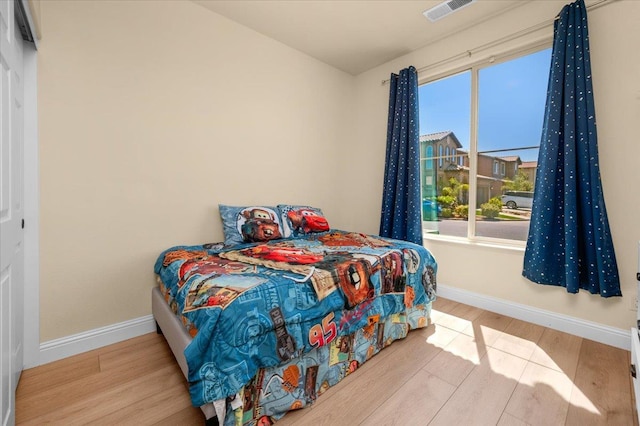2481 S Via Versilia Dr, Fresno, CA 93727 - bedroom featuring wood finished floors and multiple windows