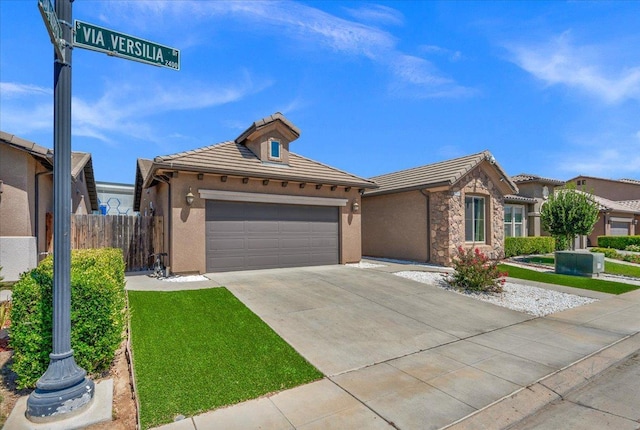 2481 S Via Versilia Dr, Fresno, CA 93727 - ranch-style house with a tiled roof, concrete driveway, stucco siding, and stone siding