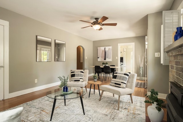 321 E Brown, Fresno, CA 93704 - living room featuring a fireplace, arched walkways, a ceiling fan, and wood finished floors