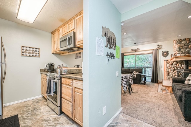 40748 Mill Run Ln Unit 5, Shaver Lake, CA 93664 - kitchen with stainless steel appliances, light brown cabinetry, open floor plan, and dark stone countertops