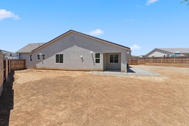 1567 Las Rosas Ave, Clovis, CA 93619 - rear view of house with a fenced backyard, a patio, and stucco siding