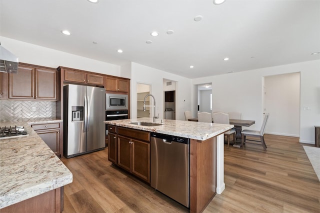 1567 Las Rosas Ave, Clovis, CA 93619 - kitchen featuring appliances with stainless steel finishes, an island with sink, decorative backsplash, wood finished floors, and recessed lighting