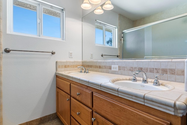 570 S Lassen Ave, Kerman, CA 93630 - bathroom with double vanity, a shower with door, and backsplash