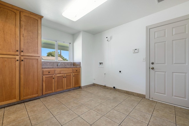 570 S Lassen Ave, Kerman, CA 93630 - washroom with hookup for an electric dryer, hookup for a washing machine, light tile patterned floors, and cabinet space