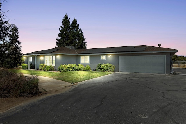 570 S Lassen Ave, Kerman, CA 93630 - view of front facade featuring stucco siding, driveway, and solar panels